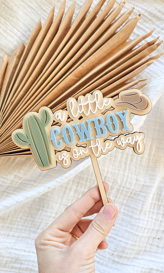 A little cowboy on its way cake topper