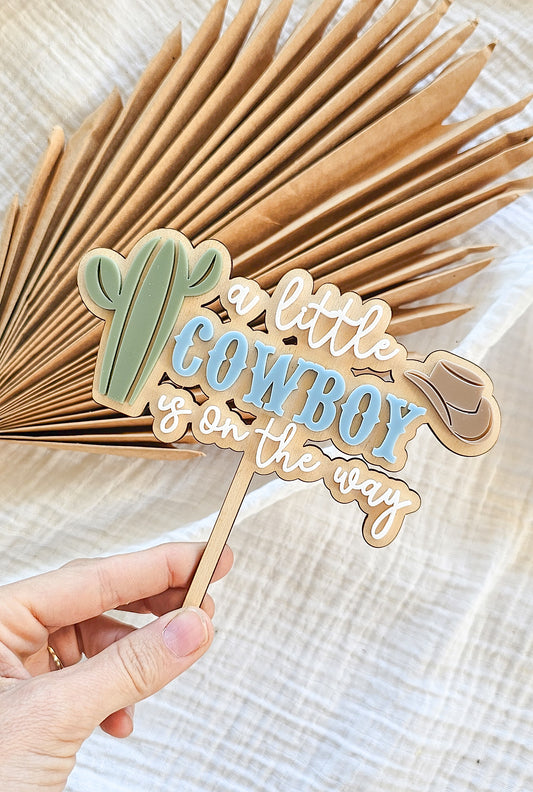 A little cowboy on its way cake topper