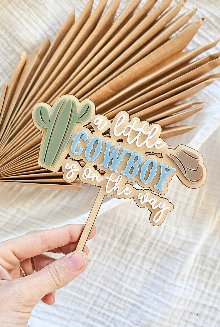 A little cowboy on its way cake topper